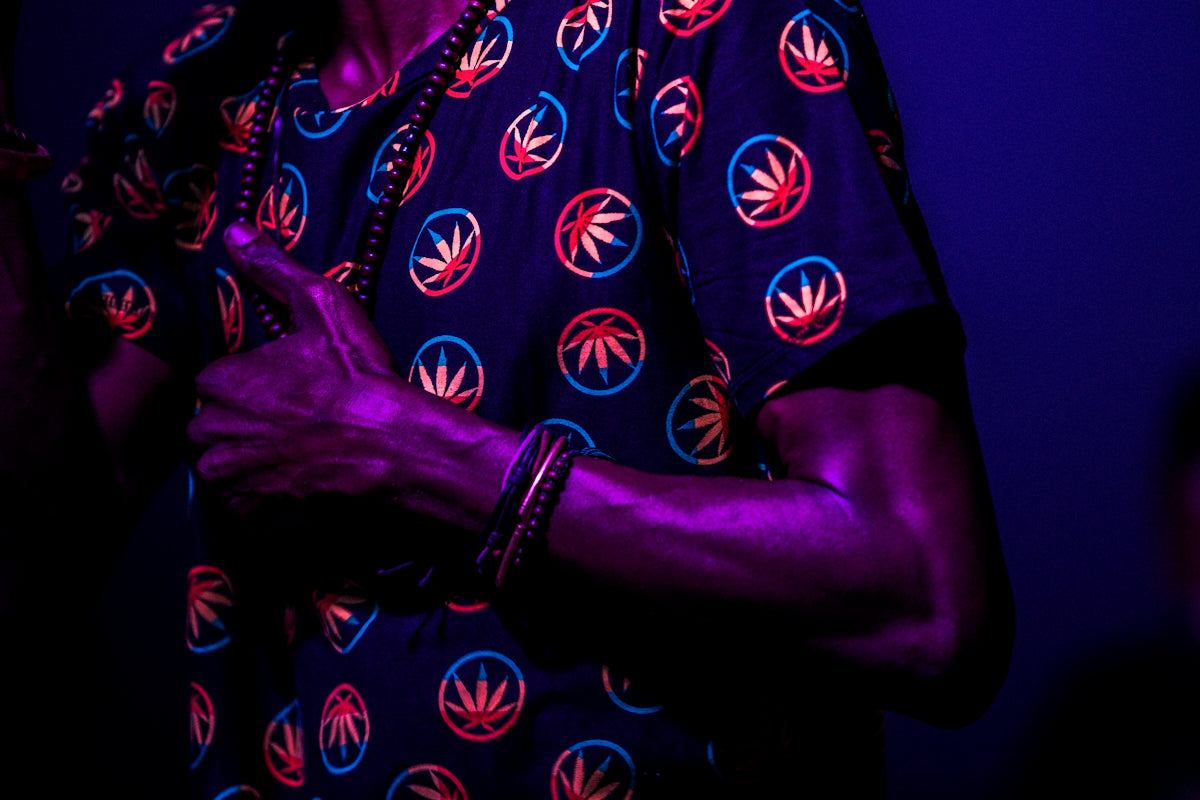 person wearing blue and red cannabis print shirt standing