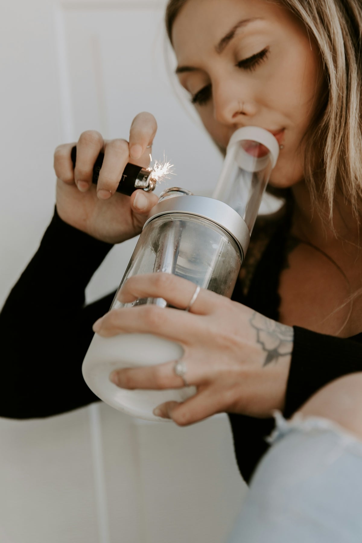 a woman is holding a glass and a cigarette
