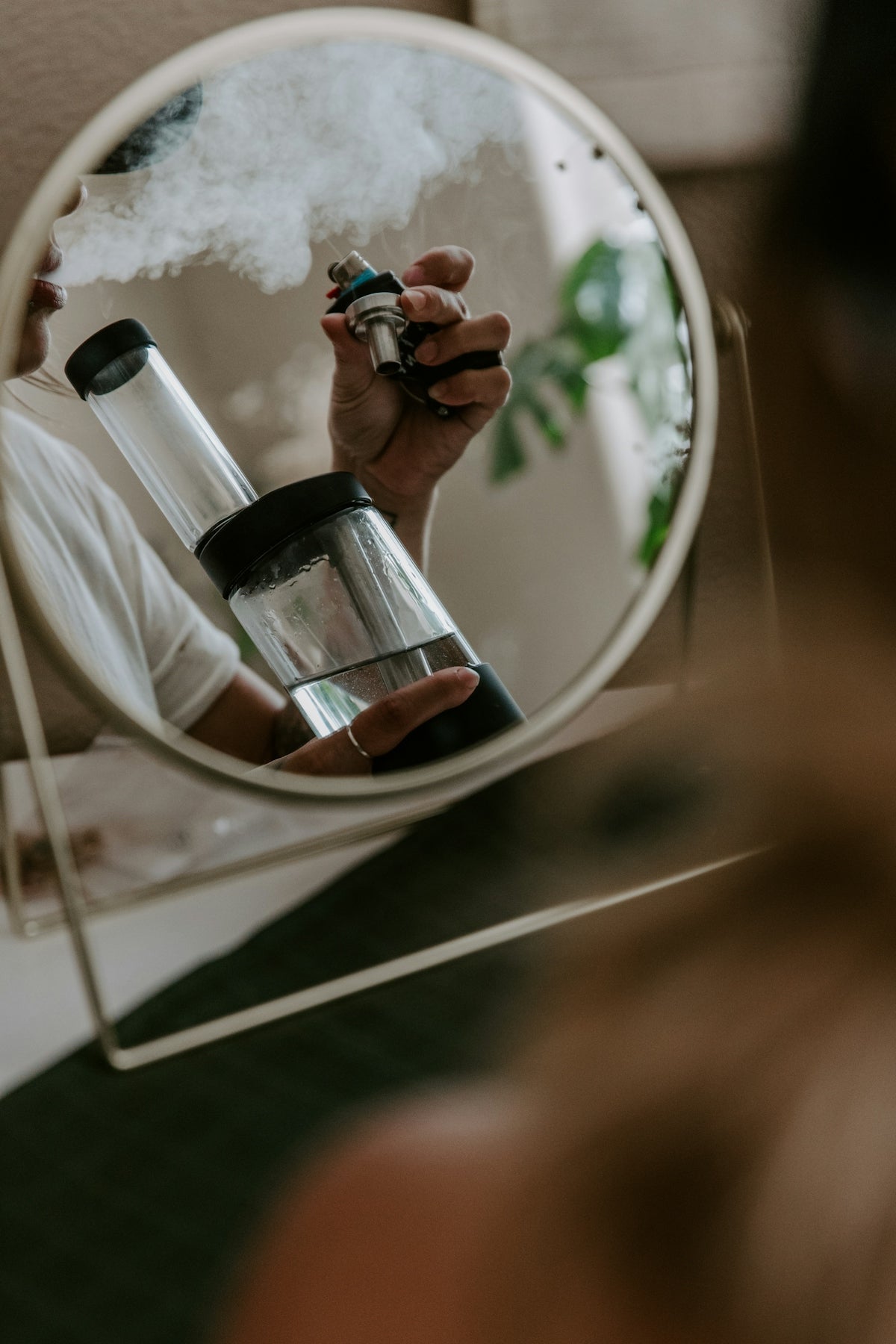 a person holding a bottle in front of a mirror